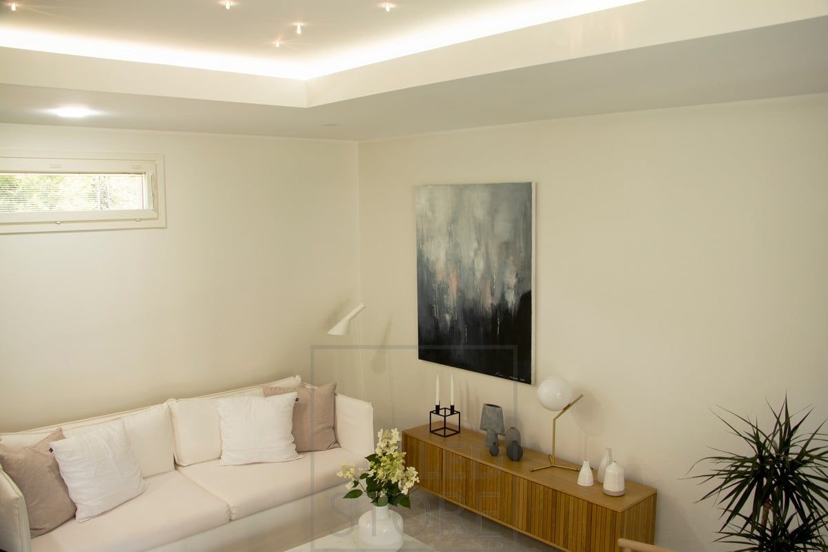 In the living room, indirect lighting directed to the ceiling. The lighting is atmospheric and soft, without glare. There are also spots in the lip that illuminate directly downwards.